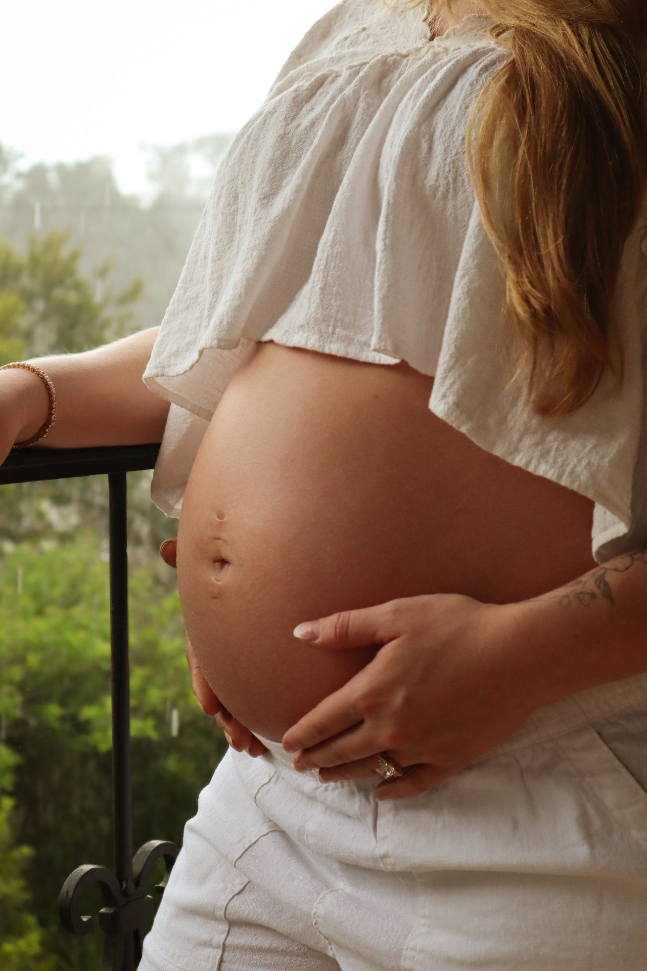 Maternity detail portrait, hands resting on the bump